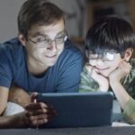 Parent with his child using blue light blocking glasses
